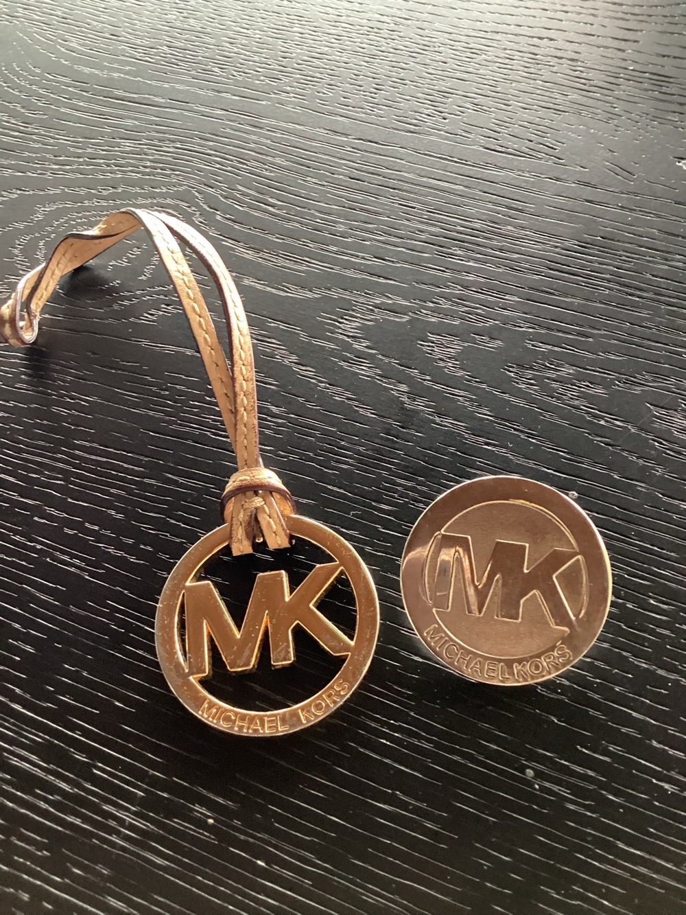 2 Michael Kors gold logo charms.